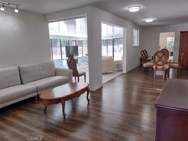 a living room with furniture a wooden floor and a large window