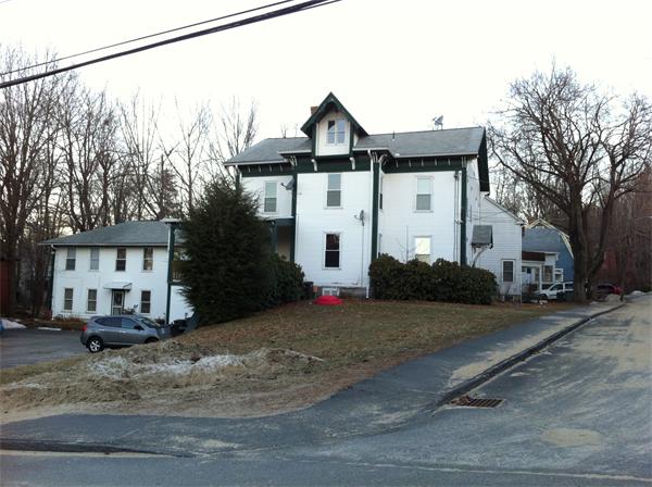 a view of a white house with a road next to a road