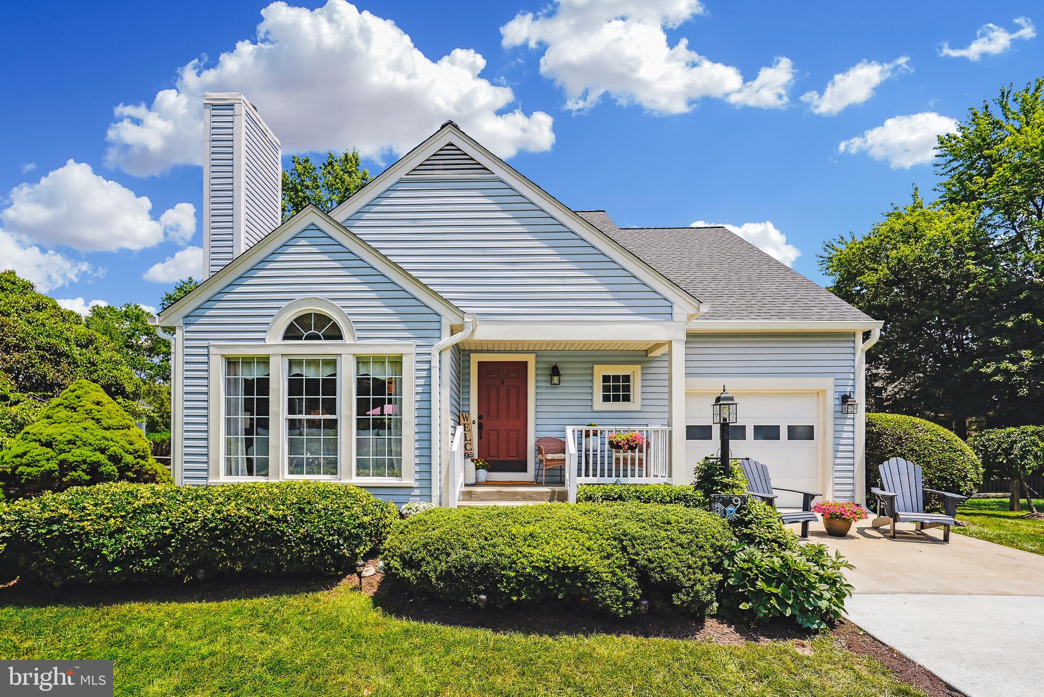 a view of a white house with a yard and potted plants