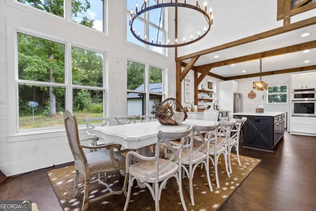 a kitchen with stainless steel appliances kitchen island a table chairs in it and wooden floors