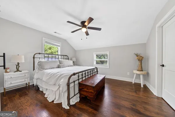 a bathroom with a granite countertop toilet sink and mirror