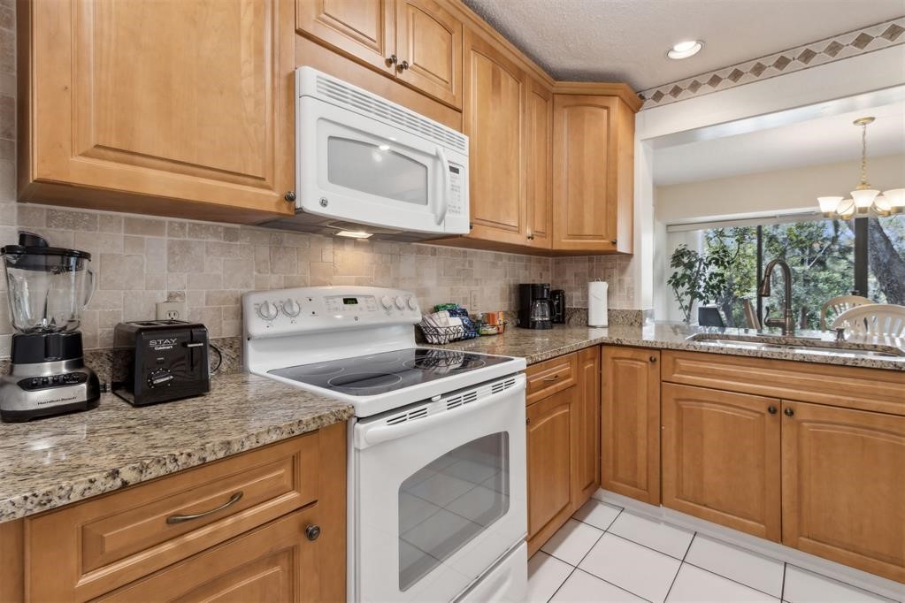 2004 Beachwood Road, Unit 2004 Fernandina Beach, FL 32034 - Photo 19 of 54 a kitchen with granite countertop cabinets stainless steel appliances and a sink