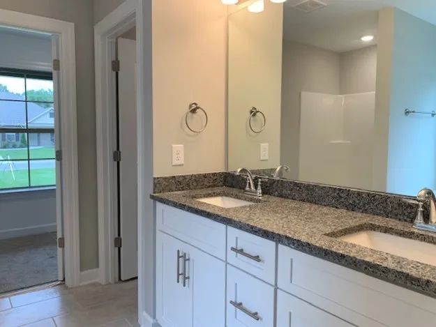 a bathroom with a granite countertop sink and a mirror