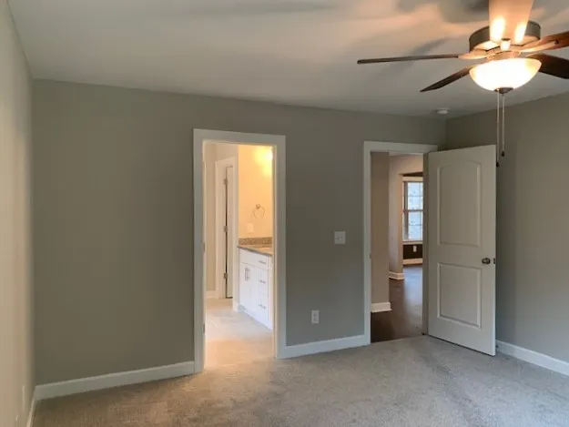an empty room with closet and a chandelier fan