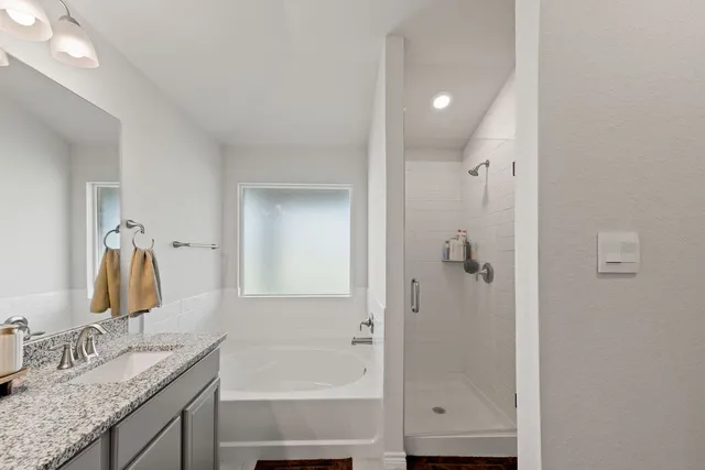 a bedroom with a bed and flat tv screen on the dresser