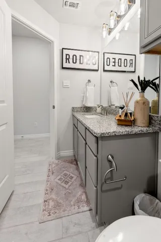 a bathroom with a granite countertop sink toilet and shower
