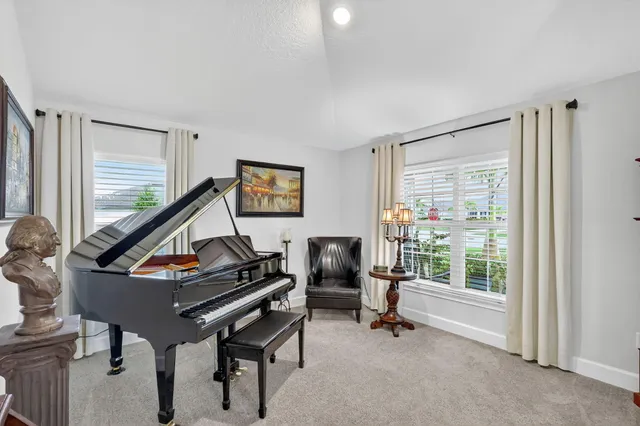 a living room with furniture a flat screen tv and a window