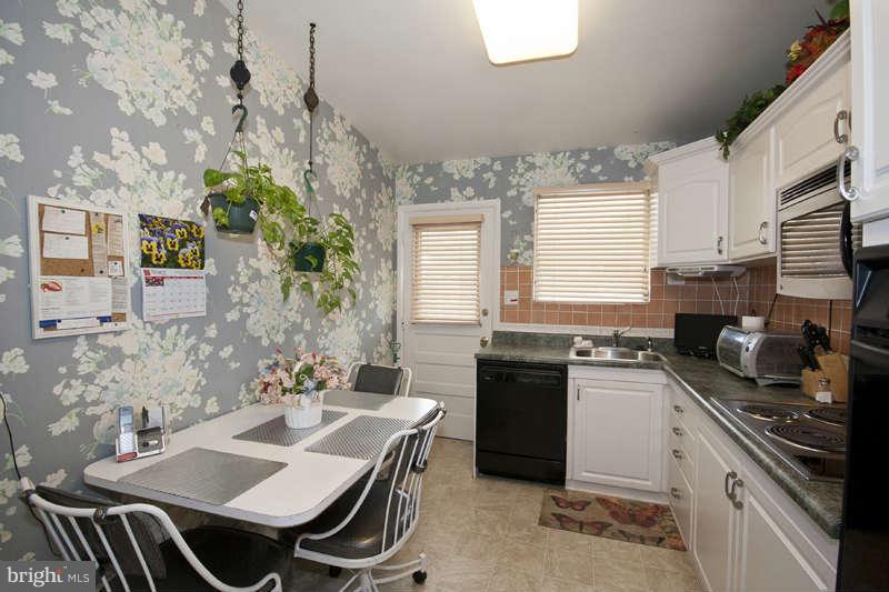 8119 Scotts Level Road Baltimore, MD 21208 - Photo 8 of 24 a kitchen with a sink stove and microwave