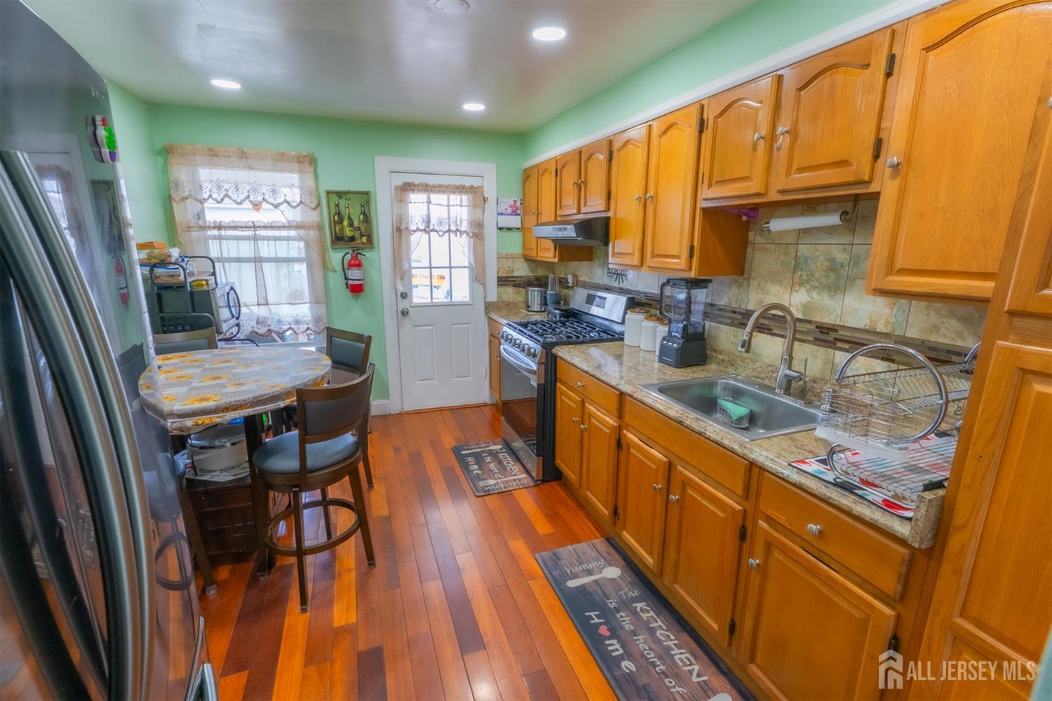 439 Ashley Street Perth Amboy, NJ 08861 - Photo 3 of 17 a kitchen with stainless steel appliances granite countertop sink stove top oven and cabinets