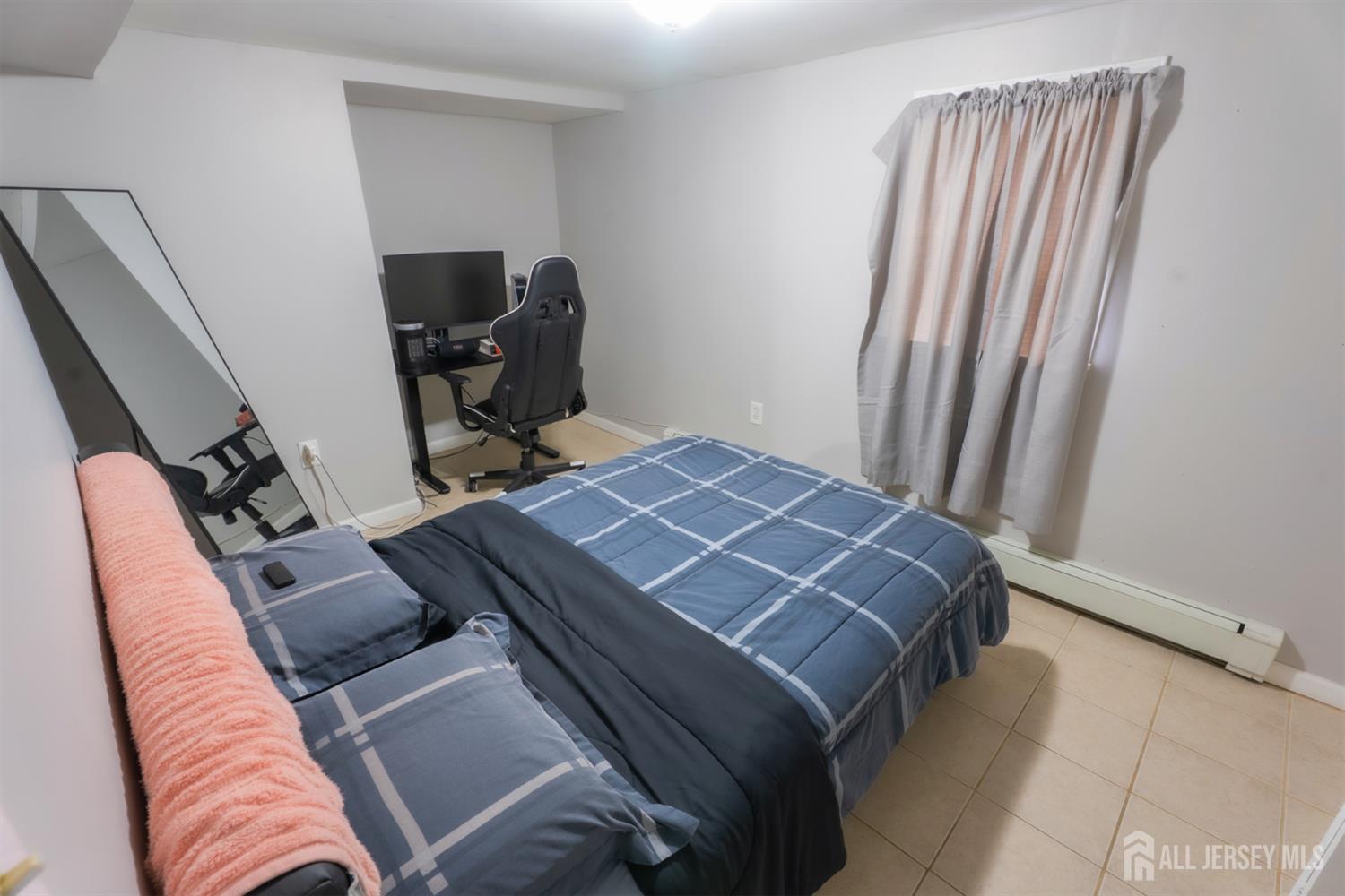 439 Ashley Street Perth Amboy, NJ 08861 - Photo 4 of 17 a bed sitting in a bedroom next to a window