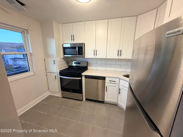 a kitchen with a stove a sink and a refrigerator