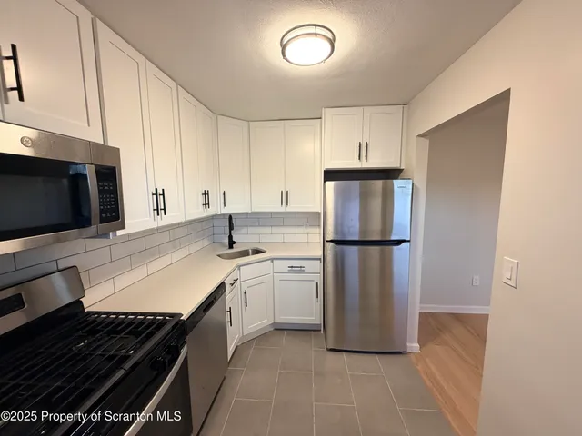 a kitchen with stainless steel appliances a refrigerator stove and microwave