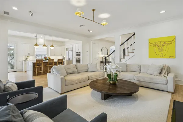 a living room with couches and a dining table with kitchen view