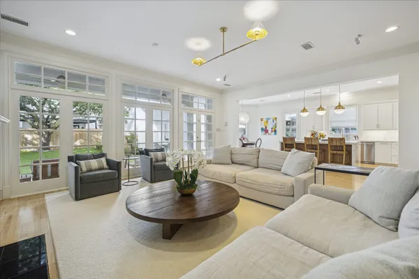 a living room with furniture and a dining table with wooden floor