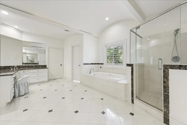 a large white bathroom with a tub sink and a shower