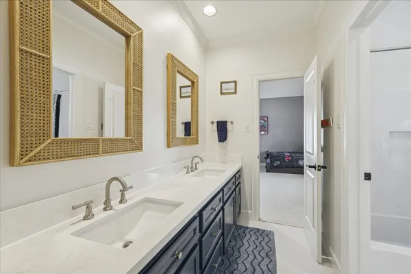 a en suite bathroom with a double vanity sink and a mirror