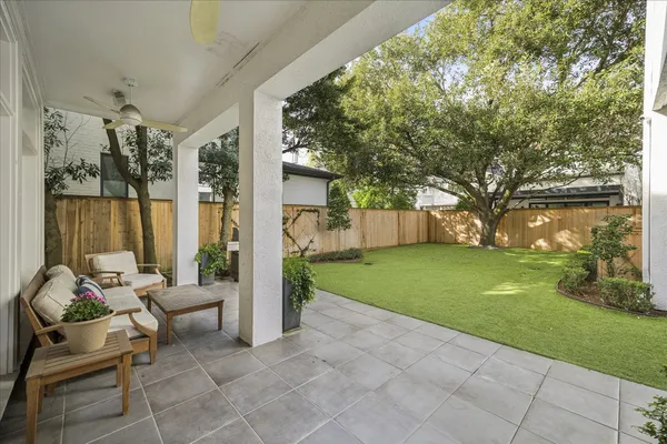a backyard of a house with fountain table and chairs