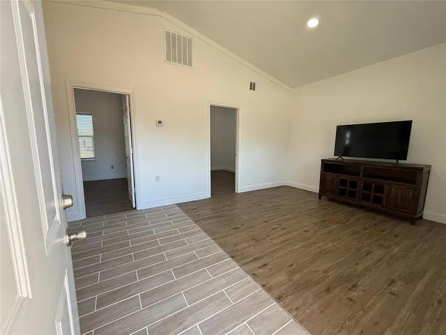 a view of a livingroom with wooden floor and a flat screen tv