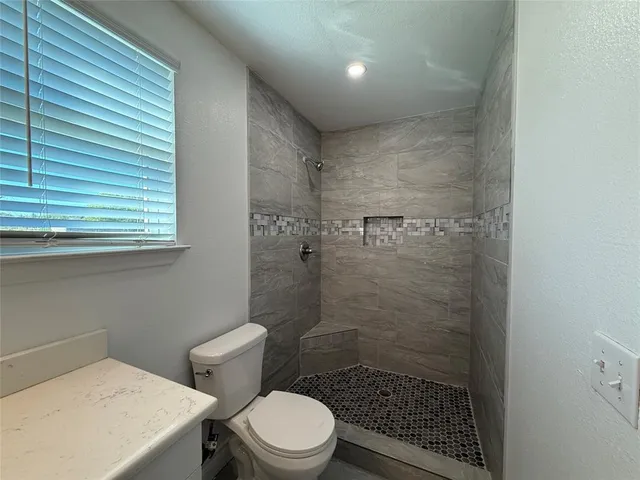 a bathroom with a toilet and a shower