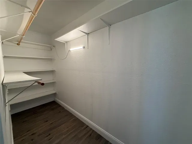 a room with a walk in closet and wooden floor