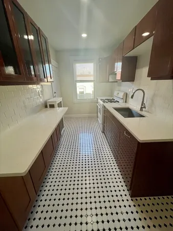 a kitchen with a sink a stove and cabinets