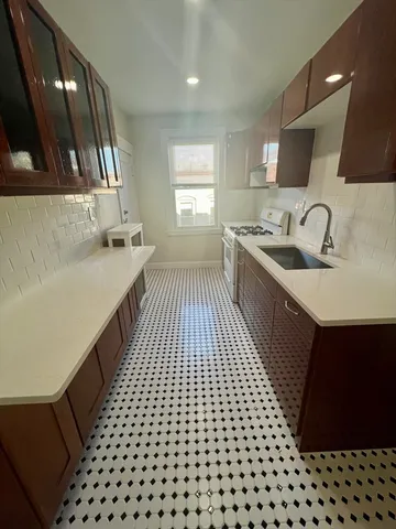 a kitchen with a sink a stove and cabinets