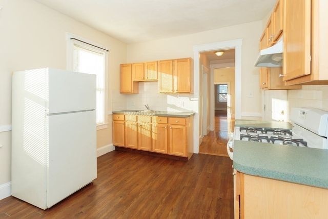 a kitchen with stainless steel appliances granite countertop a refrigerator a sink dishwasher a stove with wooden floor