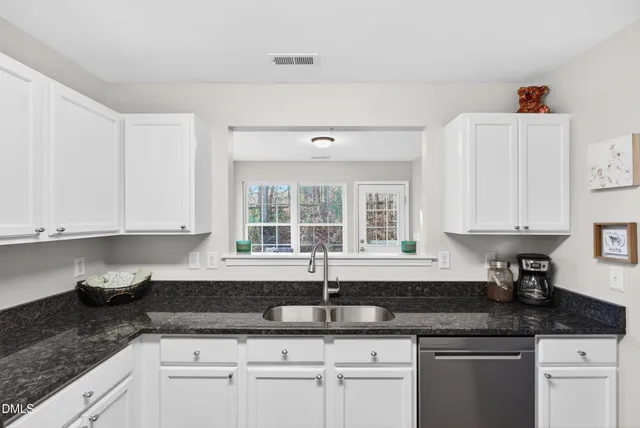 a kitchen with granite countertop a sink and cabinets