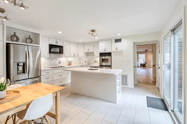 a kitchen with stainless steel appliances a refrigerator sink and cabinets