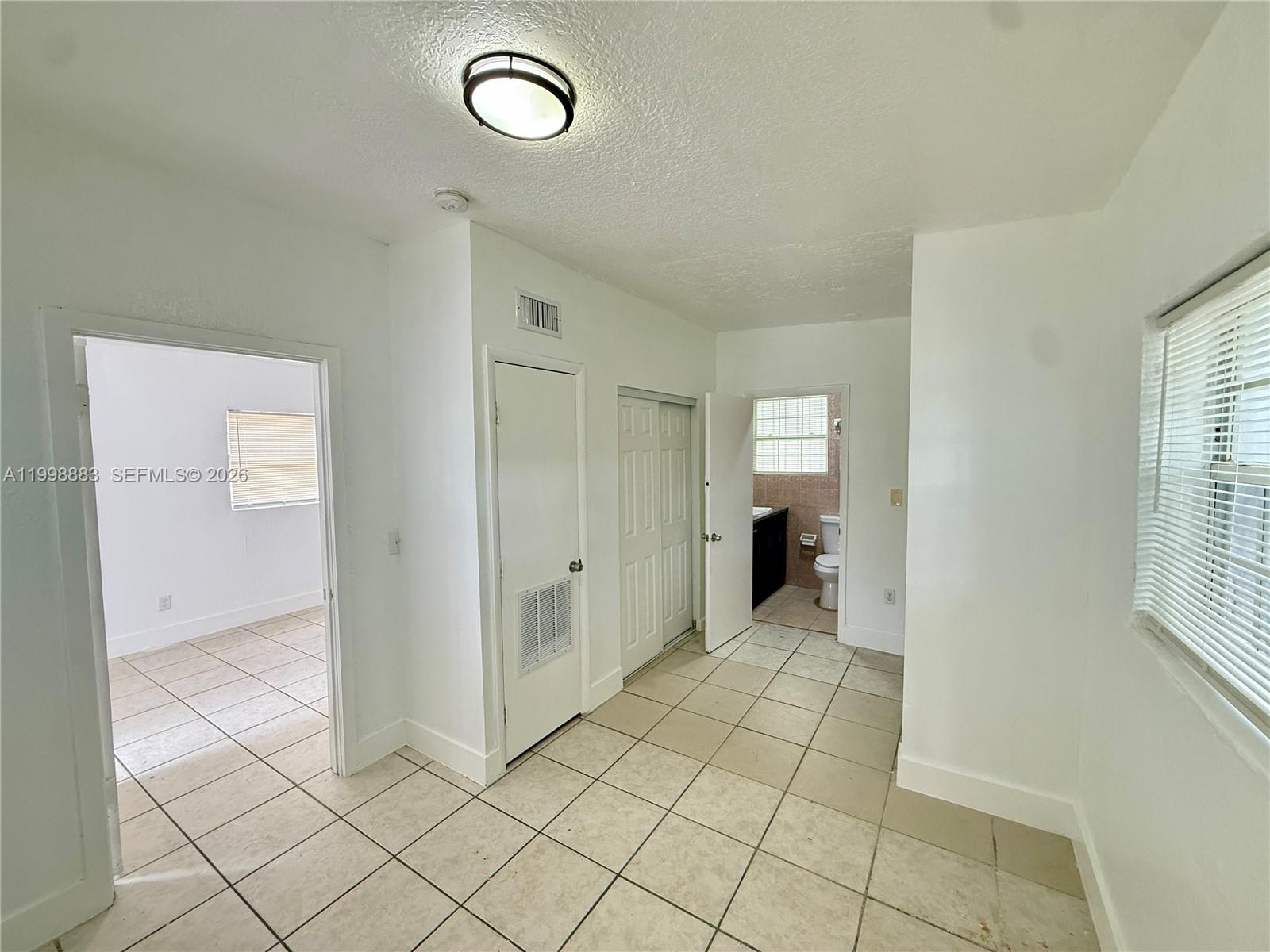 1345 Northwest 55th Street, Unit 2 Miami, FL 33142 - Photo 5 of 9 an empty room with windows and entrance