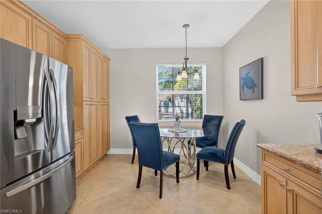 a kitchen with stainless steel appliances granite countertop a stove a sink a microwave a dining table and chairs with wooden floor