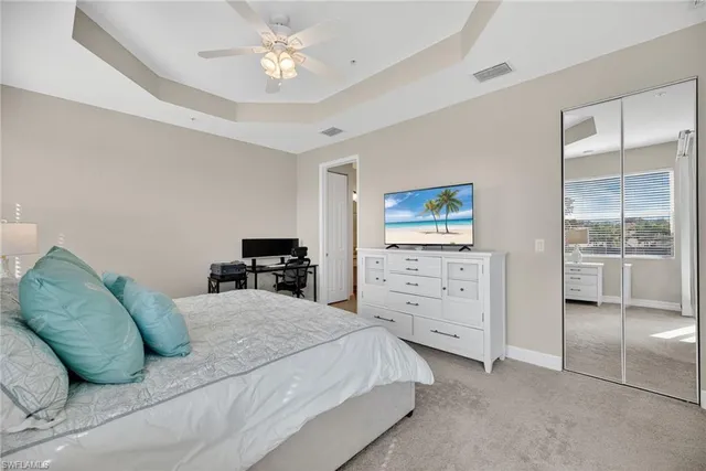 a bedroom with a large bed and a chandelier