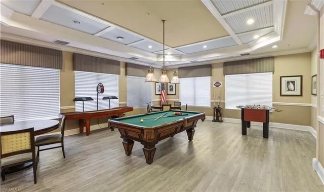 a dining room with wooden floor a chandelier a wooden table and chairs