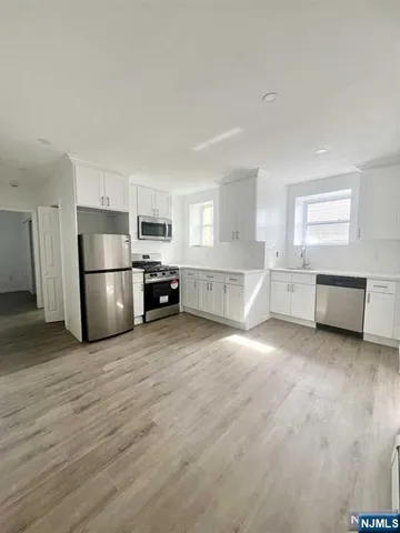 a large kitchen with a refrigerator and a stove top oven