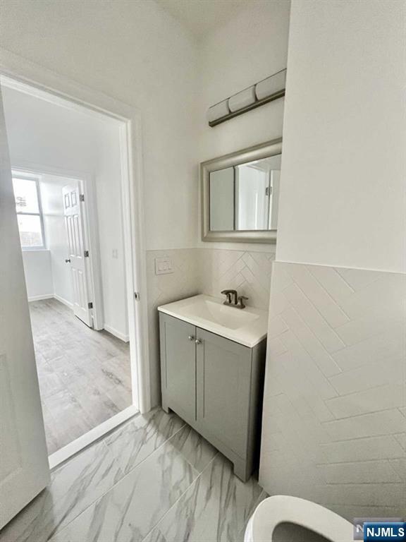 280 MacArthur Avenue, Unit 3 Garfield, NJ 07026 - Photo 3 of 15 a bathroom with a sink mirror vanity and toilet