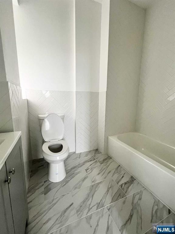 280 MacArthur Avenue, Unit 3 Garfield, NJ 07026 - Photo 4 of 15 a bathroom with a toilet and a bathtub