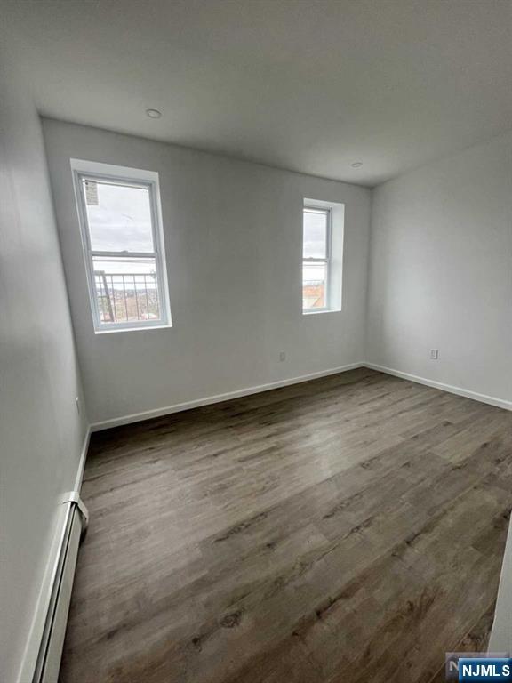 280 MacArthur Avenue, Unit 3 Garfield, NJ 07026 - Photo 6 of 15 an empty room with wooden floor and windows