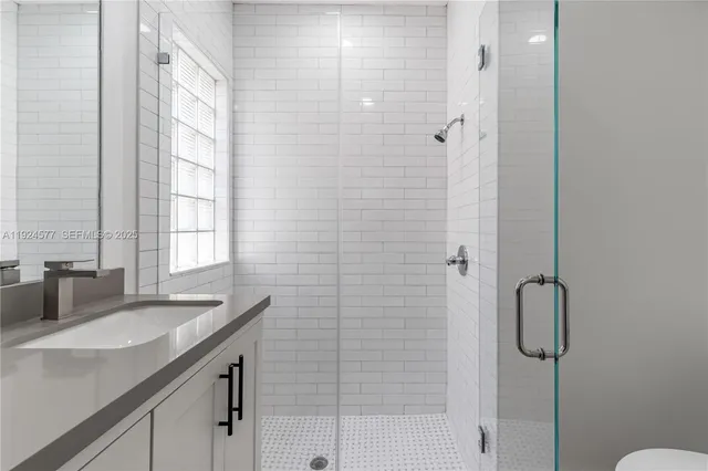 a bathroom with a granite countertop sink a shower and a mirror