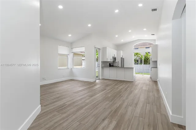 a view of empty room with wooden floor