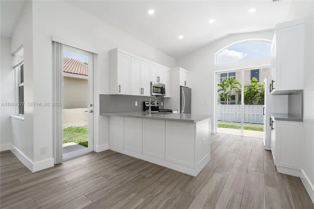 a kitchen with kitchen island wooden floors and stainless steel appliances