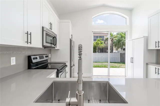 a kitchen with stainless steel appliances granite countertop a sink a stove and a microwave