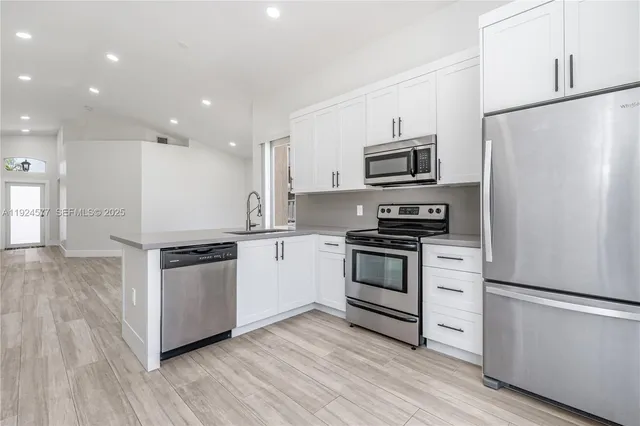 a kitchen with granite countertop a refrigerator and a stove