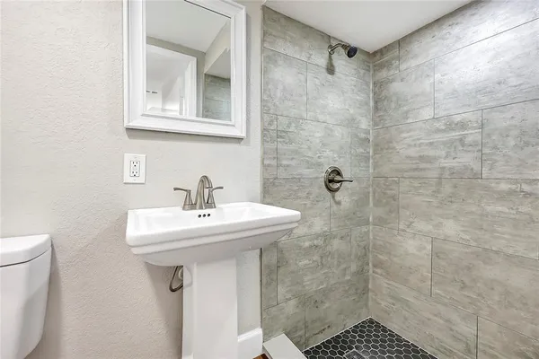 a bathroom with a sink a toilet and shower