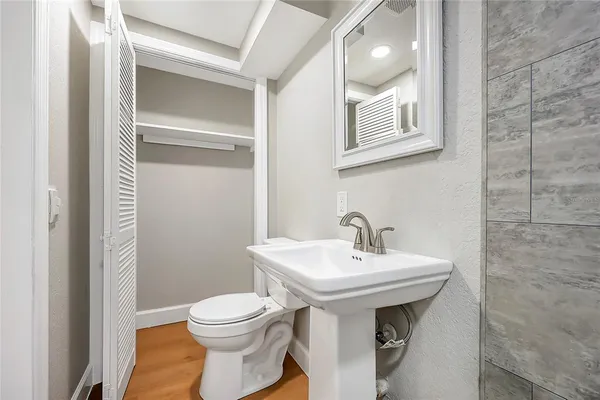a bathroom with a sink a toilet and mirror