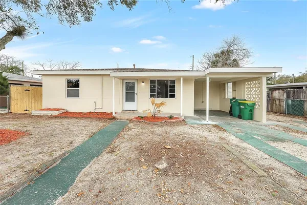 a view of a house with backyard and a tree