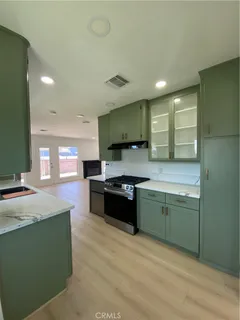 a large kitchen with stainless steel appliances granite countertop a sink and a stove