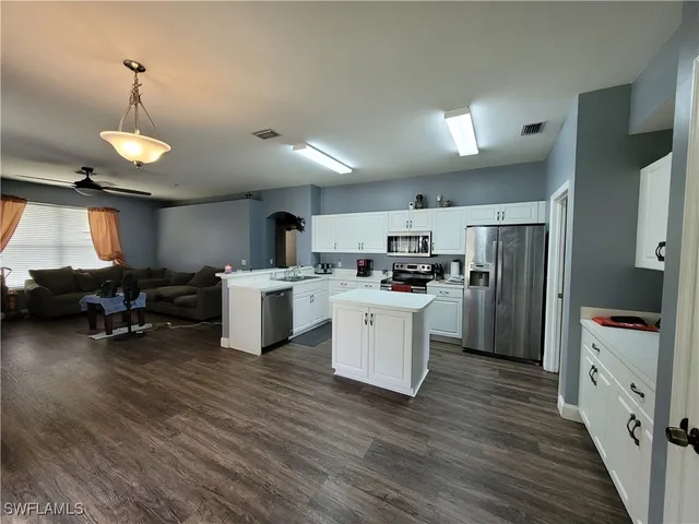 a kitchen with sink a refrigerator and chairs