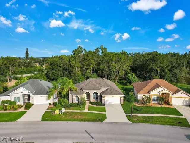 a front view of a house with a yard and trees