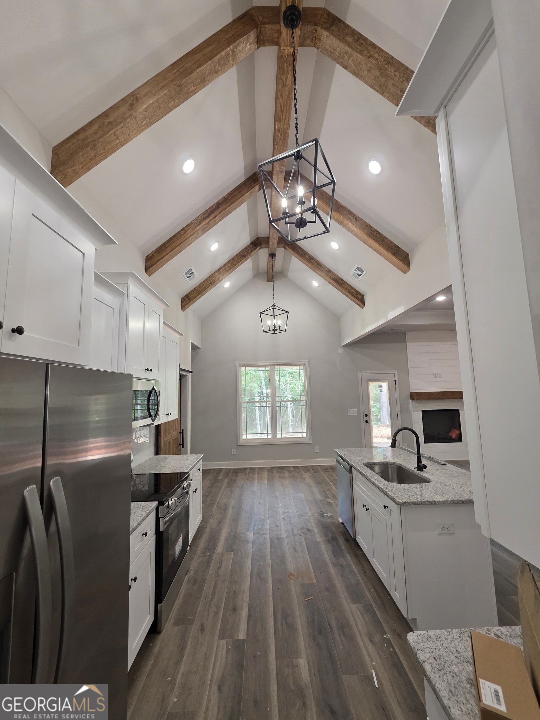 215 Panola Road Jackson, GA 30233 - Photo 5 of 16 a kitchen with stainless steel appliances a refrigerator a sink dishwasher a stove and white cabinets with wooden floor
