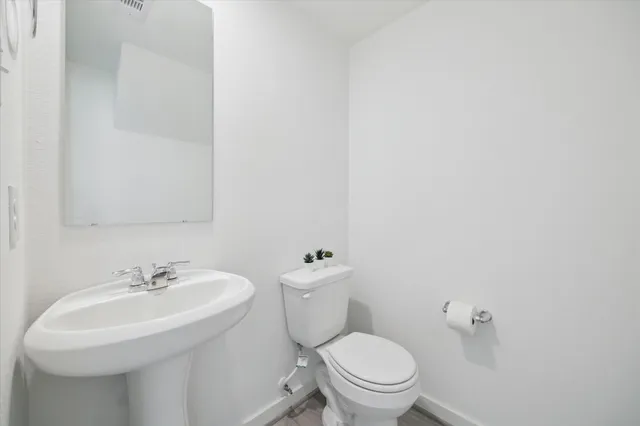 a bathroom with a sink a toilet and a mirror